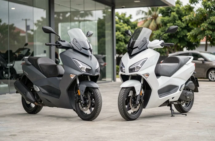 Comparaison côte à côte d'un scooter 300 et d'un scooter 400 garés devant une concession