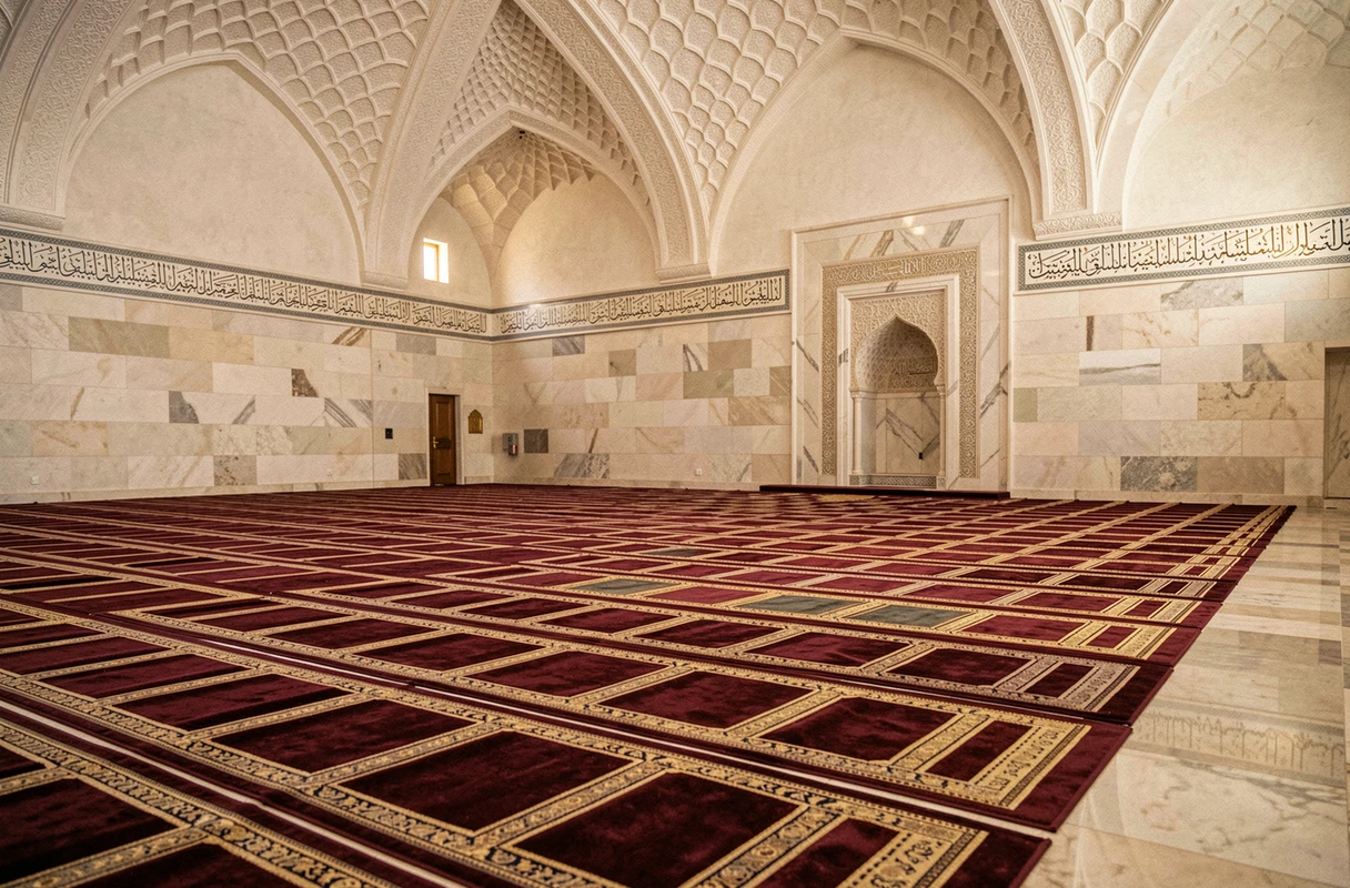 Intérieur de la salle de prière d'une mosquée avec tapis alignés et mihrab en marbre sculpté